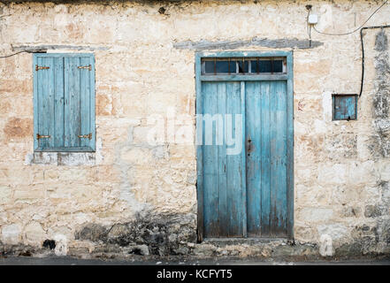 Verblasste Tür und Fensterläden im zypriotischen Dorf Agios Dimitrianos, in der Region des südlichen Zypern Paphos. Stockfoto