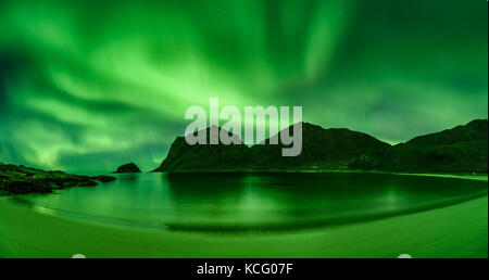Strand in der lofoten in Norwegen mit starken Grünen norther Lights Stockfoto