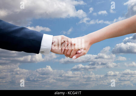 Hochzeit Paar, Hände auf blauen Himmel mit Wolken Stockfoto