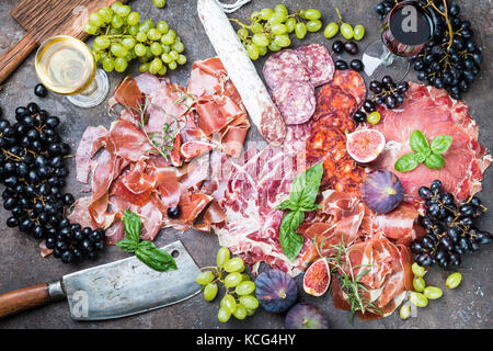 Verschiedene Arten auf Schneiden boardes mit Feigen, Trauben und Wein jamon. parmaschinken Hamon auf hölzernen Hintergrund mit Kopie Raum, Ansicht von oben. Jamon Serrano ibe Stockfoto