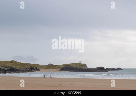 Familie und Hund Wandern am Rand des Meeres auf rhosneigr Strand, Insel Anglesey, North Wales, UK Stockfoto