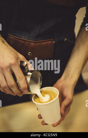 Barkeeper Kaffee in die Tasse gießen Stockfoto