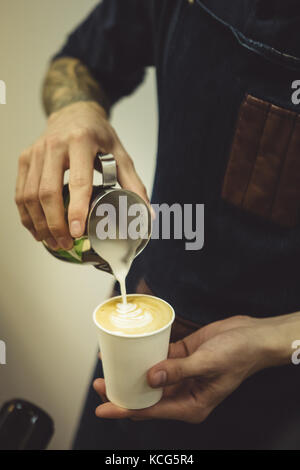 Barkeeper Kaffee in die Tasse gießen Stockfoto