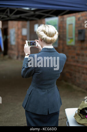 Junge Frauen in den 1940er Jahrgang raf einheitliche ein Foto mit einem Handy, UK, 2017 Stockfoto