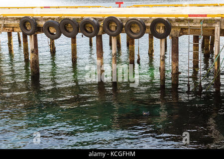 Pier gesäumt mit reifen Kotflügel für die Boote andocken, harstad in Norwegen Stockfoto