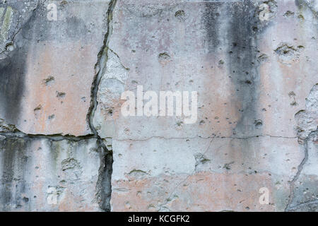 Alte, beschädigte und Risse in der Wand mit echten Einschusslöcher aus dem zweiten Weltkrieg in Danzig, Polen. Hintergrund Textur. Stockfoto