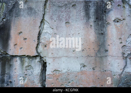 Alte, beschädigte und Risse in der Wand mit echten Einschusslöcher aus dem zweiten Weltkrieg in Danzig, Polen. Hintergrund Textur mit Vignettierung. Stockfoto