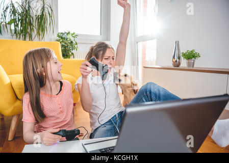 Mutter und Tochter Videospiele auf Laptop zu Hause Stockfoto