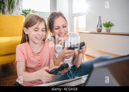 Mutter und Tochter Videospiele auf Laptop zu Hause Stockfoto