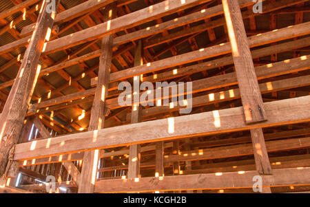 Bits von Licht durch die Sprünge, wodurch das Innere der Scheune. Stockfoto