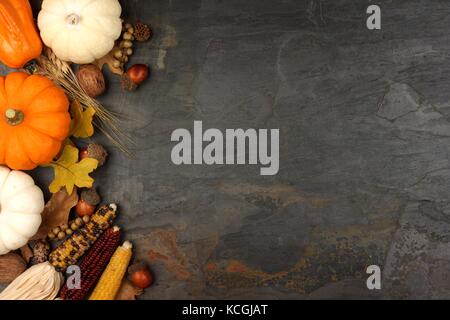 Herbst Ernte Seite Grenze mit Kürbissen, Blätter und Muttern über einen Schiefer Hintergrund Stockfoto