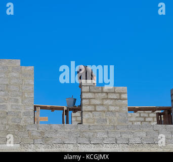Die Builder baut die Wand des Hauses aus der Asche blockieren. Arbeiter auf der Baustelle Stockfoto