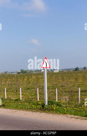 Schild weist auf eine Steilkurve auf der Fahrbahn nach links. schließen Foto oben Stockfoto