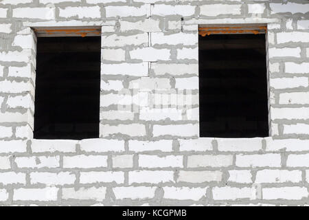 Zwei Öffnungen für Fenster im Gebäude im Bau von Gas-Silikat Bausteine von weißer Farbe. Bau einer Wohnung Haus, fotografiert c Stockfoto