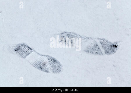 Nahaufnahme der Fußspuren eine Links auf den Schnee im Winter Saison. Wandern zu Fuß Mann nach Schneefall. Stockfoto