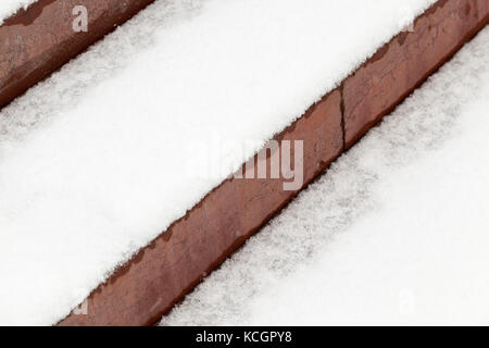 Fotografiert close-up alte Schritte der Rot. Das Gebäude ist mit weißen Schnee bedeckt. Foto in einem Winkel genommen Stockfoto