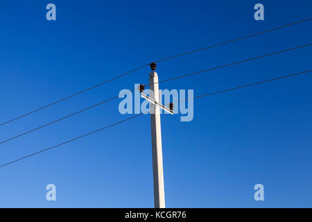 Fotografiert in der Nähe von Wolken am blauen Himmel. kleine Tiefenschärfe. Im Vordergrund der Power line Stockfoto