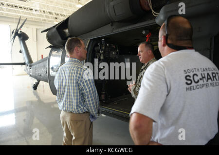 Südcarolina Lieutenant Governor Kevin l. Bryant spricht mit US-Army Chief Warrant Officer 4 Tripp hutto, ein UH-60 Blackhawk Pilot, über die s.c. Hubschrauber aquatic Rescue Team Mission bei mcentire joint National Guard base, 21. Juli 2017. Lt. Gouverneur Bryant mit South Carolina Luft- und Army National Guard Führung über base Missionen gesprochen und erhielt eine Windschutzscheibe Tour der Installation mit Ausrichtungen der verschiedenen Flugzeuge, die von South Carolina National Guard Flieger und Soldaten betrieben. (Us Air National Guard Foto von Master Sgt. caycee Watson) Stockfoto