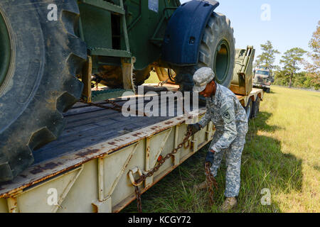 Spc. Marcus Robinson, ein Bauingenieur an der 178th Engineer Battalion, South Carolina Army National Guard zugeordnet, entlastet die schwere Ausrüstung für den Transport von Puerto Rico auf der McEntire Joint National Guard. S.C. Sept. 29, 2017. Ingenieure aus South Carolina werden gesendet Puerto Rico mit Wiederaufnahme Bemühungen zu helfen, nachdem Hurrikan Maria die Insel verwüstet. (U.S. Air National Guard Foto von Tech. Sgt. Jorge Intriago) Stockfoto