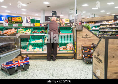 Arbeiten in einem Supermarkt - ein Mitarbeiter in einem Morrisons Supermarkt arbeiten. Stockfoto