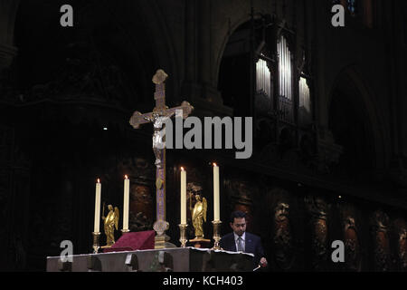 Die Verehrung der Heiligen Krone aus Dornen in der Kathedrale Notre-Dame (Notre-Dame de Paris) in Paris, Frankreich. Ein Knecht leuchten Kerzen auf dem Altar der Kathedrale Notre-Dame, bevor die Verehrung. Die Krone ist für die Verehrung in der Kathedrale der erste Freitag des Monats sowie während der Fastenzeit Freitags und am Karfreitag vorgestellt. Stockfoto