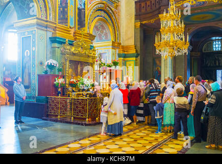 POCHAYIV, UKRAINE - 30. AUGUST 2017: Heilige Ikone der Pochayiv Mutter Gottes in Flamme mit einer Schlange von Pfarrern in der Dormition Cathedral, Pochayiv Lavra Stockfoto