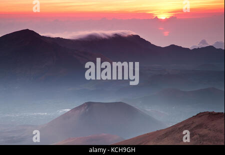 Sonne über den Wolken im Haleakala Krater steigt, Haleakala National Park, Maui, Hawaii Stockfoto