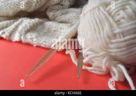 White sheep wool yarn being made into a knitted handmade wearable product. knitting - a creative hobby. Stockfoto