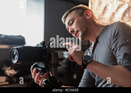 Fotograf im Studio stellt die Kamera und sagt die Kamera Stockfoto