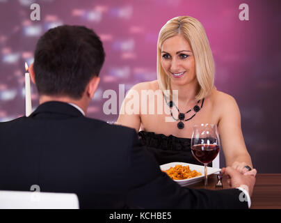 Glückliche schöne Paar Hand in Hand im Restaurant Stockfoto