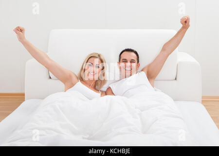 Porträt von Liebespaar Waking Up im Bett Stockfoto
