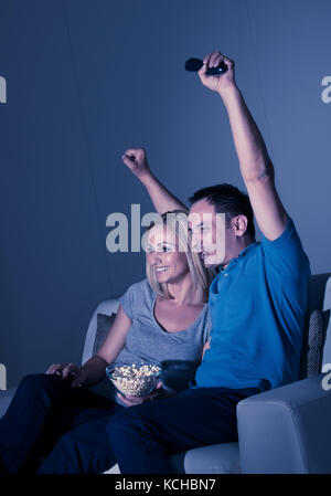 Aufgeregt Paar Fernsehen Und Popcorn Essen Stockfoto