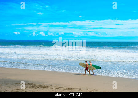 Canggu, Bali, Indonesien - 19 Jan, 2017: Surfer gehen mit Surfbrett am Strand. Die Insel Bali ist einer der Weltbesten surfen Reiseziele Stockfoto