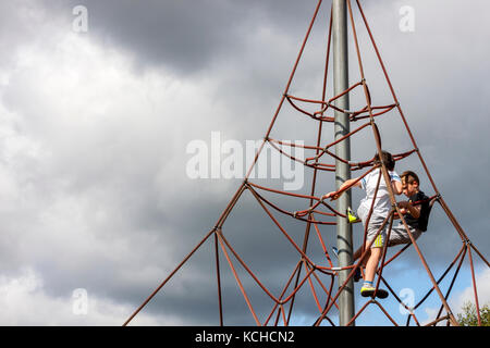 Die jungen Klettern Apparate in Spielplatz Stockfoto