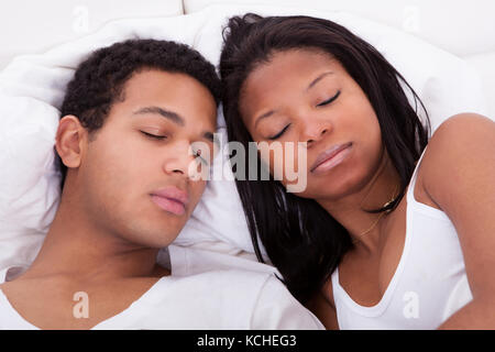 Porträt eines jungen Paares schlafend auf dem Bett Stockfoto