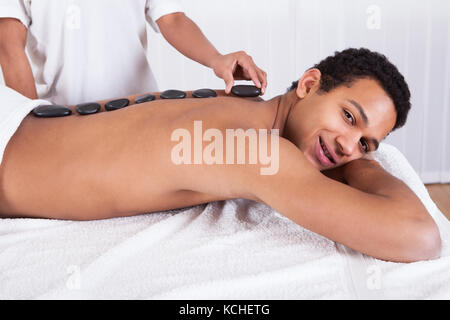 In der Nähe von Frau Hand Hot Stone auf den Menschen zurück Stockfoto