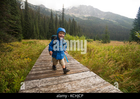 Ein glückliches Kind (junge) Wanderungen auf der Promenade um Gibson See in Kokanee Glacier Provincial Park, British Columbia. Stockfoto