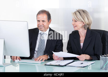 Gerne reife Geschäftsmann und geschäftsfrau am Computer suchen Stockfoto