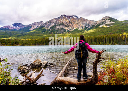 Frau mit Blick auf Pyramid Lake mit Pyramid Mountain im Jasper National Park in den kanadischen Rockies an einem kalten Septembertag im Jahr 2015 Stockfoto