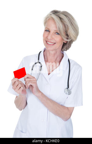 Reife Frau Doktor Holding Visitenkarte Over White Background Stockfoto