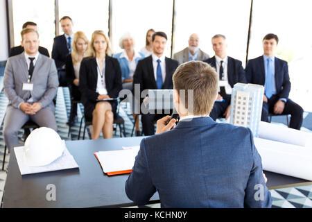 Zielgruppe Geschäftsleute und Investoren am Training Zimmer sitzen, Konferenzsaal, Ansicht vom Lautsprecher Tabelle mit Dokumenten, Modell der modernen multi Sto Stockfoto