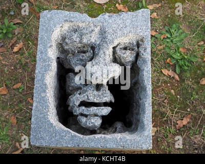 Sculpted Bausteine, aus denen die Gesichter in leere Seiten an dem Denkmal zu Massakriert Dorfbewohner in Sant'Anna di Stazzema, Provinz Lucca, Toskana, Italien Stockfoto