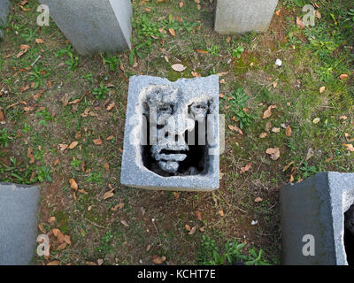 Sculpted Bausteine, aus denen die Gesichter in leere Seiten an dem Denkmal zu Massakriert Dorfbewohner in Sant'Anna di Stazzema, Provinz Lucca, Toskana, Italien Stockfoto