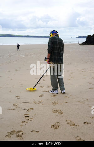 Mann mit einem Metalldetektor auf Tenby Beach, South Wales, UK. Stockfoto