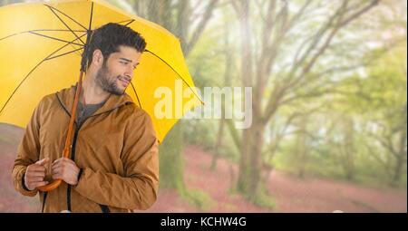Digital composite der Mann im Herbst mit Regenschirm in hellen Wald Stockfoto