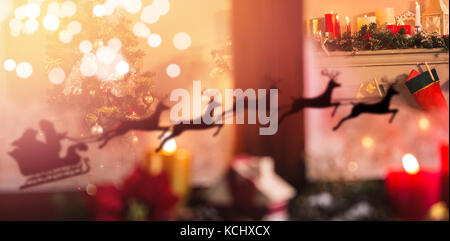 Silhouette der Weihnachtsmann und Rentier gegen Weihnachtsbaum und Weihnachtsstrumpf zu Hause Stockfoto