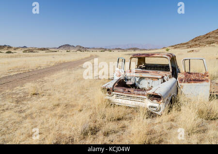 Wrack der abgebrochenen Oldtimer zwischen trockenem Gras neben der Piste im Damaraland, Namibia, Südafrika Stockfoto