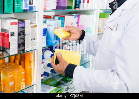 Mittelteil des Chemikers holding Medizin Boxen Stockfoto