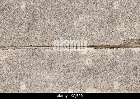 Zusammen zwei Betonplatten von der Gebäudewand angeschlossen. an der Oberfläche der Platten kleine Kies fixiert ist gegen Faktor Umwelt zu schützen. Stockfoto