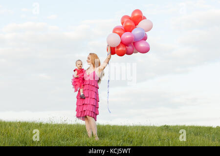 Portrait von Mutter und Tochter. Sie auf die Skyline stehen. Mutter einer Tochter und ein Bündel von Luftballons in den Händen hält Stockfoto